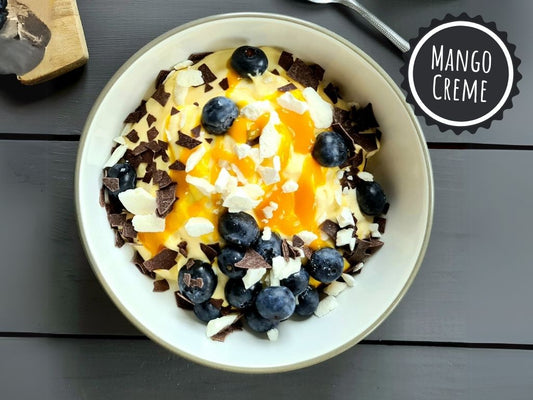 LUFTIGE MANGO-SAHNE-CRÉME MIT FRISCHEN HEIDELBEEREN, ZARTBITTERSCHOKOLADE & BAISERSPLITTERN